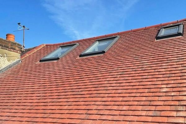 Completed loft renovation exterior with skylight windows and tiled roof