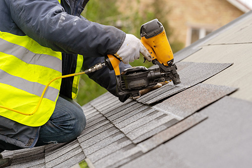 Roofer installing new roof tiles in Watford