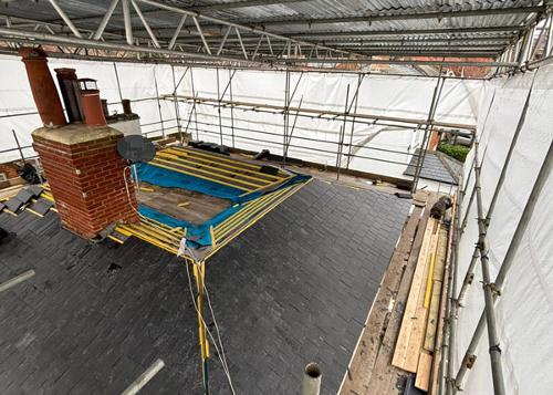 In progress roof repair surrounded by scaffolding