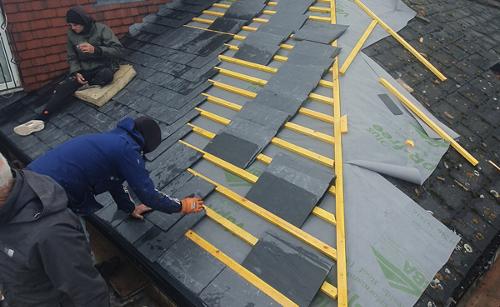 Team working on fixing roof tiles